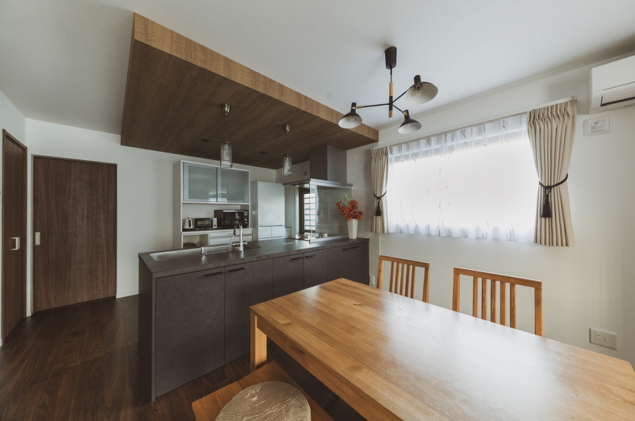 天井をあえて少し下げて木目調のクロスを貼ることでキッチンに特別感を出しています。