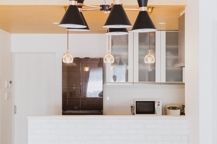 木目調の天井クロスとペンダントライトを飾ることで、キッチンをより印象的な空間に仕上げています。