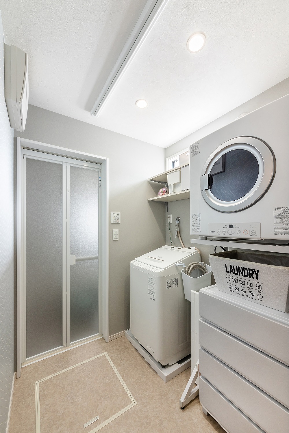脱衣室には洗濯機と乾燥機を配置しています。スペースに合った収納ボックスを利用し、シンプルかつスマートな収納を実現しました。