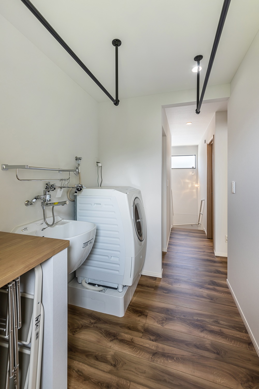 約3帖の広々としたランドリールーム。<br />
造り付けのカウンターは洗濯物を畳んだり、アイロンをかけたりするのにとても便利。<br />
泥や汚れの付いた靴や衣服をスムーズに洗えるようにスロップシンクも設置しました。<br />
洗濯に関する一連の作業を効率よく行うことができ、家事の時短にもつながります。