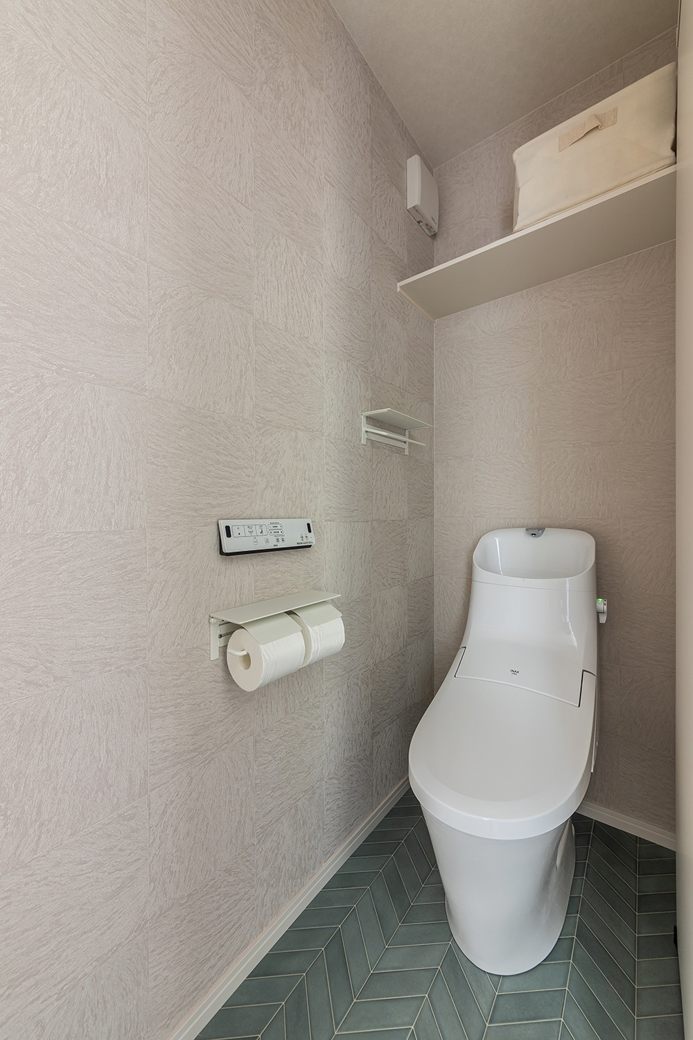 グリーンがかったブルーのヘリンボーン床が可愛いトイレ。<br />
シンプルでありながらも個性の光る空間に仕上がりました。