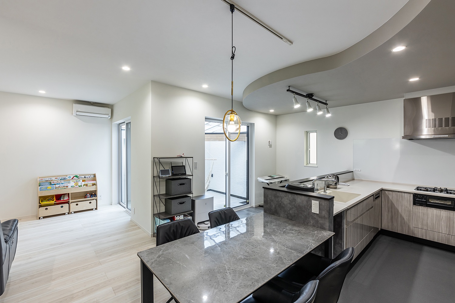 存在感のある照明が目を惹くダイニング。<br />
高級感のある大理石調のダイニングテーブルが家族の団らんや、おもてなしのシーンをより華やかに演出してくれます。<br />
また、ダイニングテーブルをキッチンの横に配置したことで、料理の準備や後片付けのしやすい家事動線を実現しました。<br />
