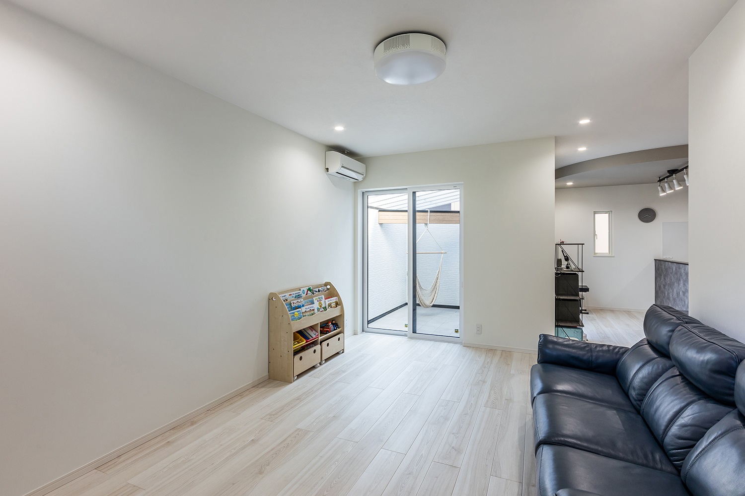 真っ白な壁紙と木目調の床が、ナチュラルな印象のリビング。<br />
プロジェクター時計や緑が美しいピクチャーウィンドウなど遊び心を取り入れ、居心地の良いリビング空間に仕上げました。<br />
また、リビング横には、リビングとダイニング両方から出入りできるインナーバルコニーがございます。<br />
外壁に高さがあるため、プライベート空間を心置きなく楽しむことができます。<br />
