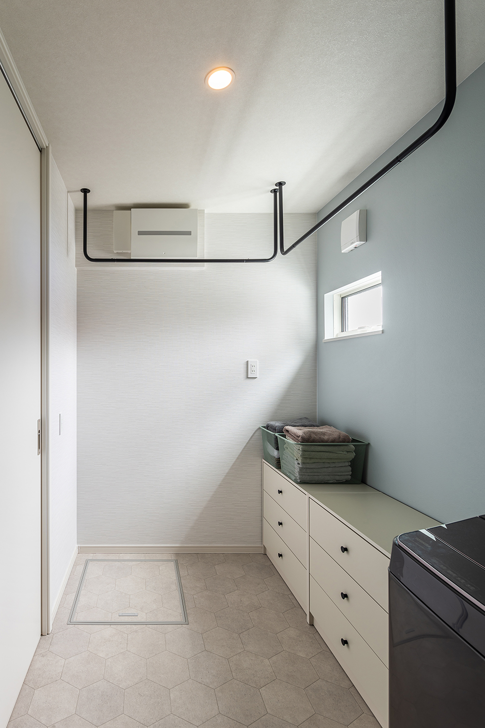 スッキリと洗練された脱衣室。<br />
天井にはブラックのランドリーパイプを設置しました。デザイン性が高く空間を有効活用でき、室内での洗濯物干しに便利です。