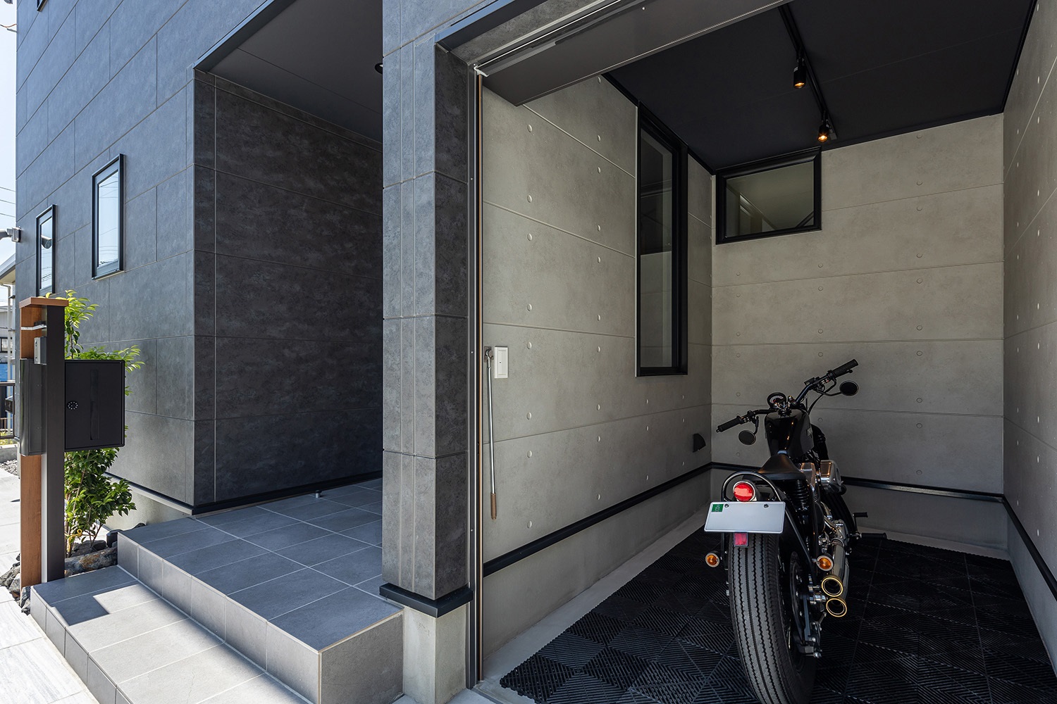 玄関横のバイク用ガレージは、コンクリート調の外壁がとてもクール。<br />
バイクをスタイリッシュに演出するのに最適な空間です。