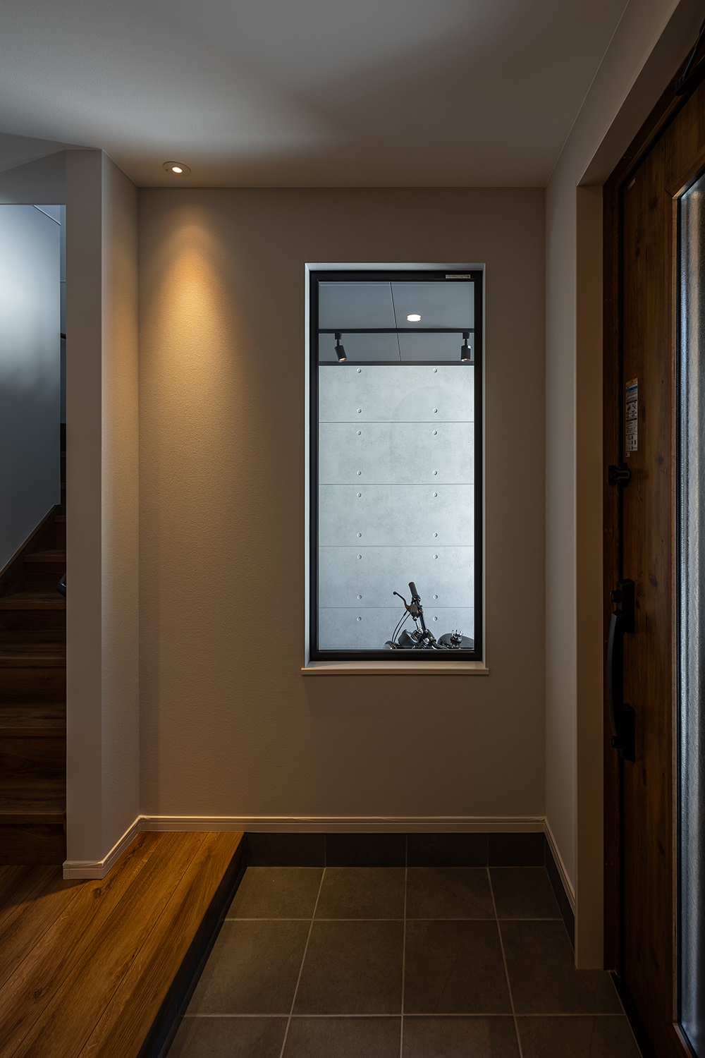 スッキリと開放感のある玄関。<br />
大きなFIX窓からはガレージの様子を眺めることができます。