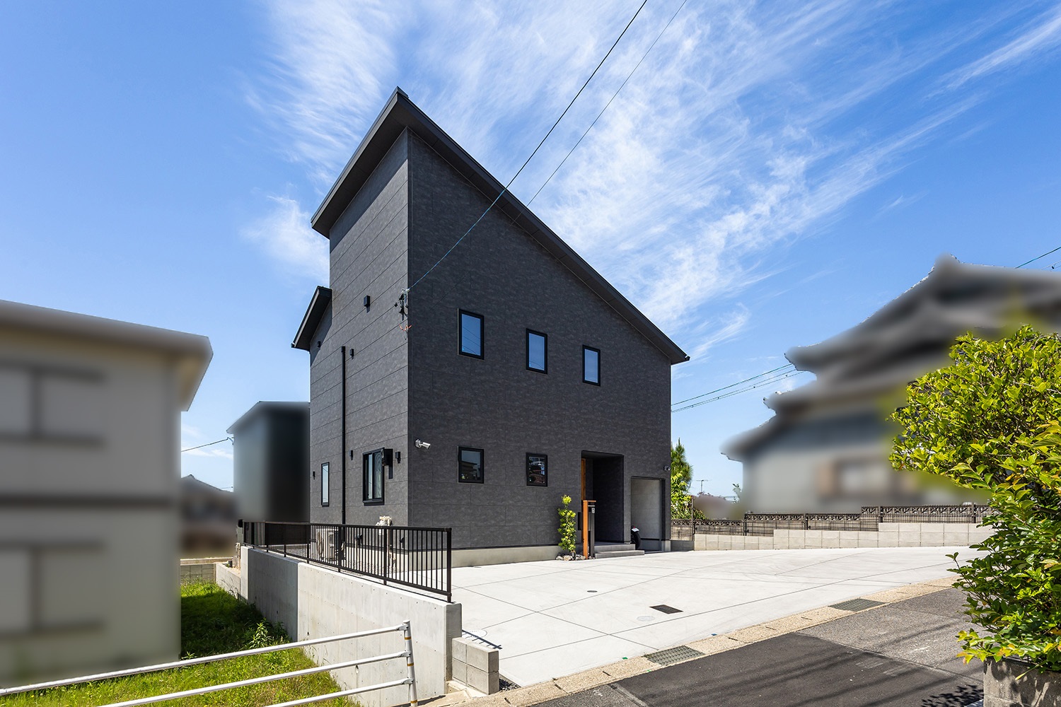 黒い外壁にシャープな片流れ屋根が印象的な外観。<br />
木目調の玄関ドアが、外観の黒と調和しながら自然のぬくもりを与えてくれます。