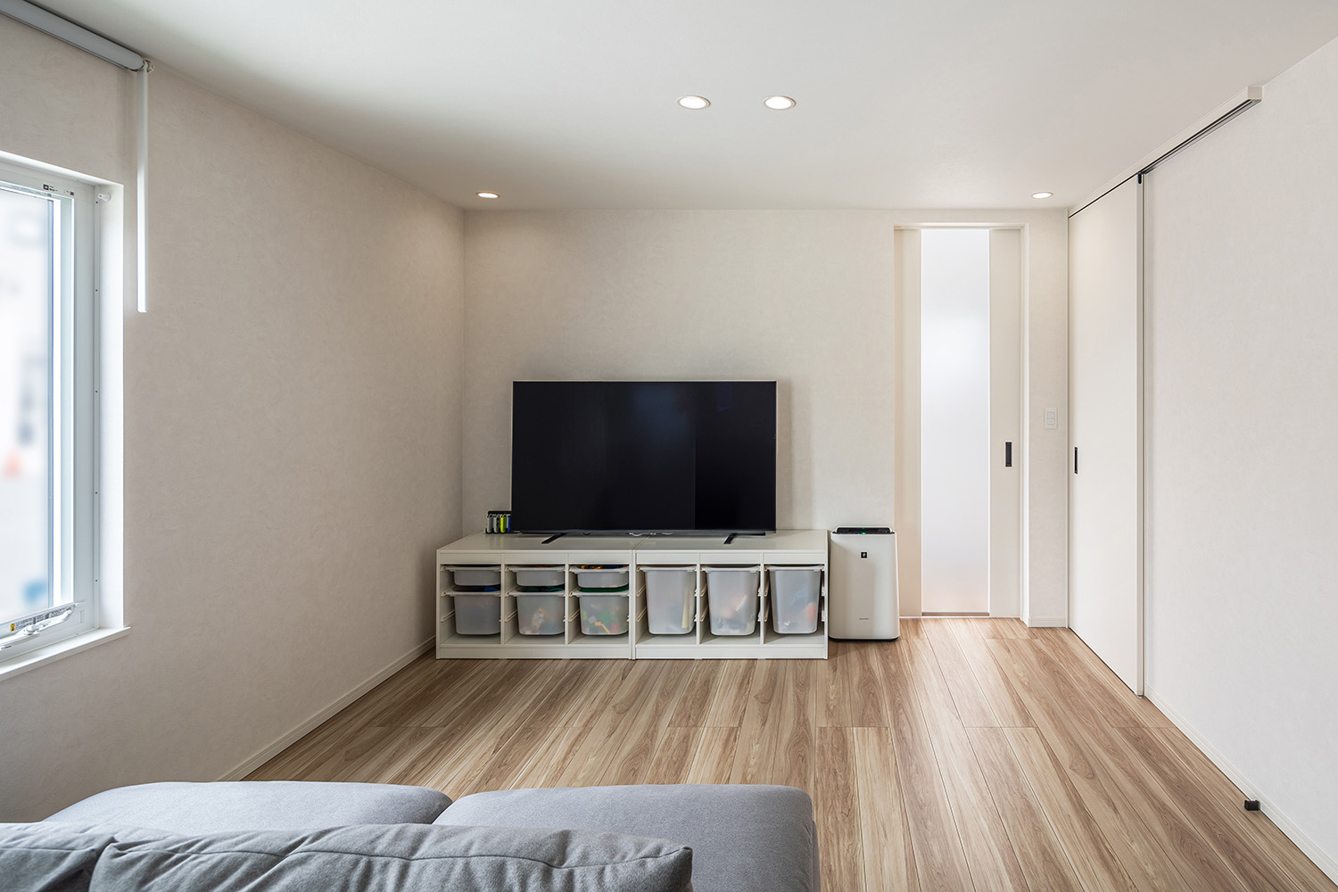 柔らかな光が降り注ぐリビングは、白色とグレーの家具で優しい雰囲気にまとめました。<br />
また、収納にも特化したテレビボードを配置したことで、お子様のおもちゃもすっきりと片付けられ、いつも美しくお部屋を保つことができます。