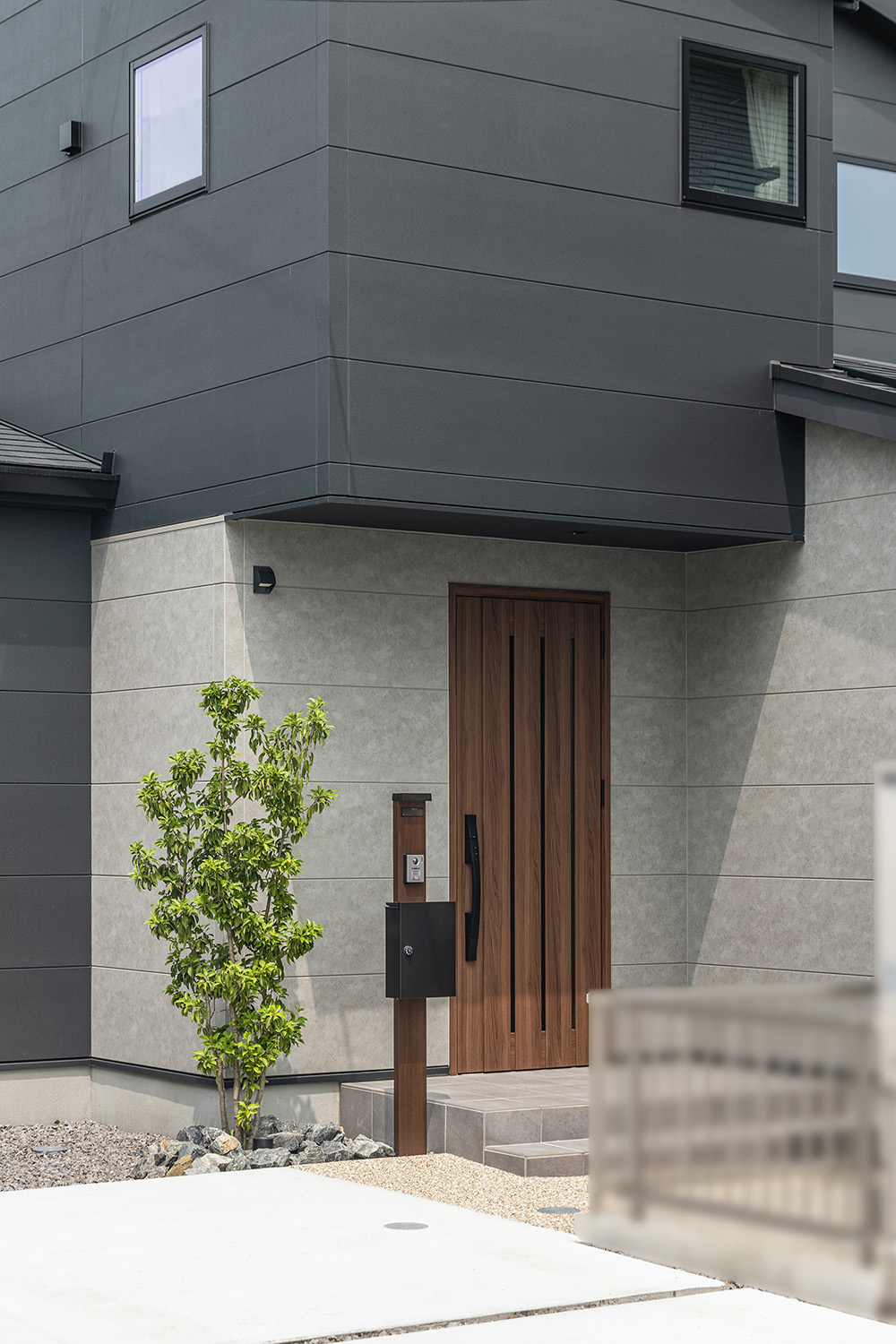 玄関には、温かみのある木目調ドアとスタイリッシュな門柱を設置。<br />
ツートンカラーの外観との組み合わせ抜群です。