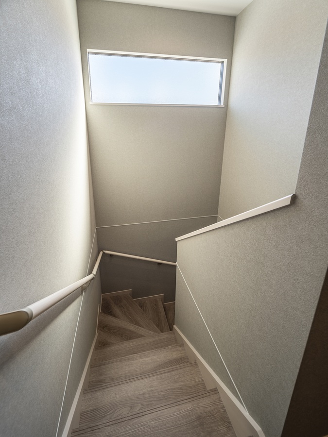 階段は洗練されたグレイッシュカラーで統一。壁面に設けた横長の窓から差し込む自然光が、空間全体を柔らかく包み込みます。